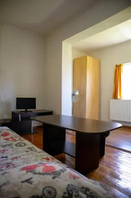 a room with a desk and a bed and a tv at Alpin Guest House in Sapareva Banya