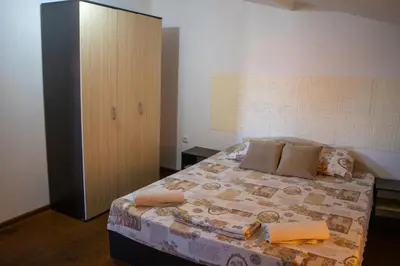 a bedroom with a large bed and a cabinet at Alpin Guest House in Sapareva Banya