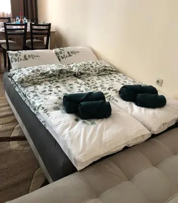 two beds with green pillows on them in a bedroom at Luxury apartment 1 Free Underground Secure Parking in Pazardzhik