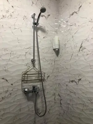 a shower in a bathroom with a wall at Luxury apartment 1 Free Underground Secure Parking in Pazardzhik