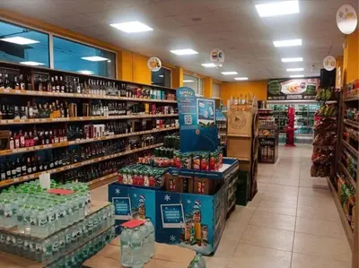 a store aisle with bottles of alcohol on shelves at Luxury apartment 1 Free Underground Secure Parking in Pazardzhik