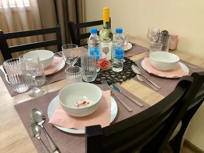 a table with plates and bowls and wine bottles on it at Luxury apartment 2 Free Underground Secure Parking in Pazardzhik