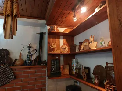 a kitchen with wooden shelves with dishes and other items at Стаи за гости Валеьови in Bansko