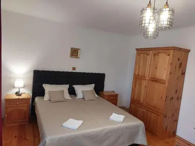 a bedroom with a bed with two towels on it at Стаи за гости Валеьови in Bansko