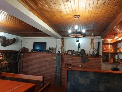 a room with a brick wall and a ceiling with a chandelier at Стаи за гости Валеьови in Bansko