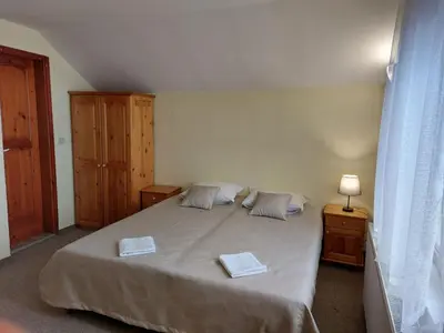 a bedroom with a large bed with two towels on it at Стаи за гости Валеьови in Bansko
