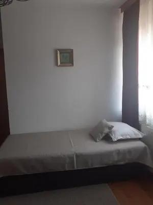 a bed in a room with a picture on the wall at Стаи за гости Валеьови in Bansko