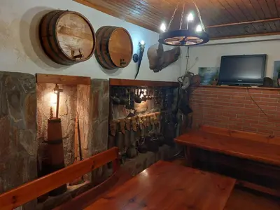 a room with a wooden bench and wooden barrels on the wall at Стаи за гости Валеьови in Bansko