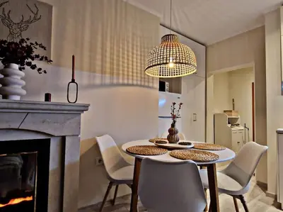 a dining room with a table and chairs and a fireplace at 1 bedroom luxury apartment Milena -free parking in Pamporovo