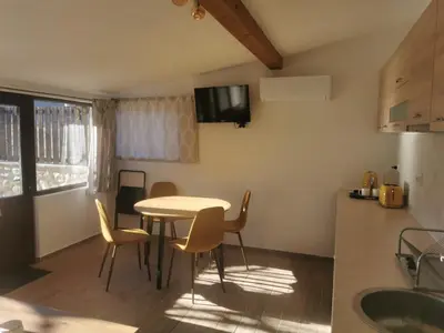a kitchen and dining room with a table and chairs at Ергини in Dobrinishte
