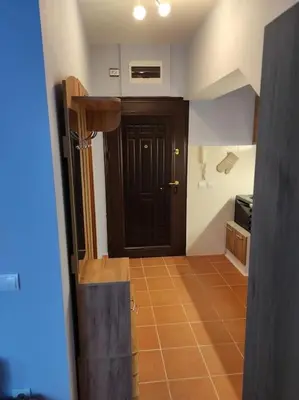a hallway with a black door and a tile floor at Your Place Borovets in Borovets