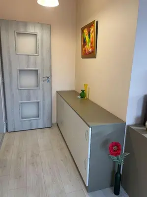 a room with a door and a vase with a flower at Mila's 1 Bedroom Apartment in Sofia