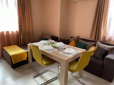 a dining room table with chairs and a couch at Mila's 1 Bedroom Apartment in Sofia