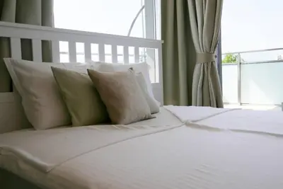 a white bed with pillows and a window at Charmful new flat with Hill view in Plovdiv