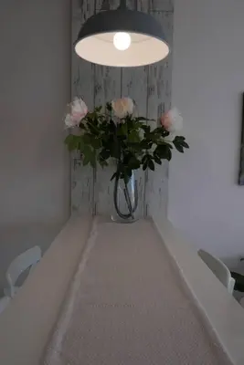 a vase of flowers sitting on a table under a light at Charmful new flat with Hill view in Plovdiv