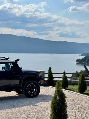 a black jeep parked next to a body of water at Villa ART in Dospat