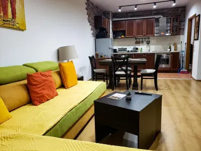 a living room with a green couch and a table at Semiramida gardens Apartment 23 in Borovets
