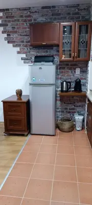 a kitchen with a refrigerator and a brick wall at Semiramida gardens Apartment 23 in Borovets