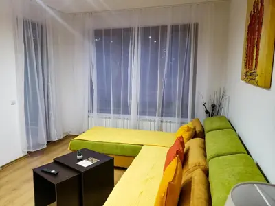 a living room with a green couch and a window at Semiramida gardens Apartment 23 in Borovets