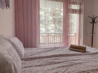 a bedroom with a large bed with a window at Semiramida gardens Apartment 23 in Borovets