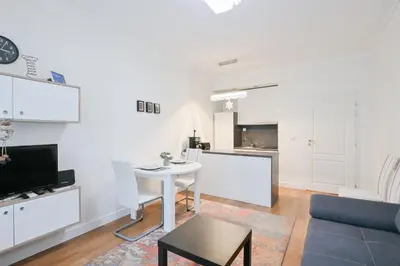 a white living room with a table and a couch at St. Ivan Rilski flat in Sofia