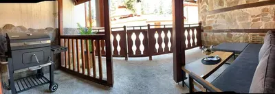 a living room with a grill on a balcony at Olive Apartment with terrace B100 in Grand Resort Pamporovo in Pamporovo