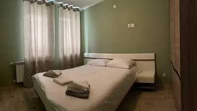 a green bedroom with a bed with towels on it at Olive Apartment with terrace B100 in Grand Resort Pamporovo in Pamporovo