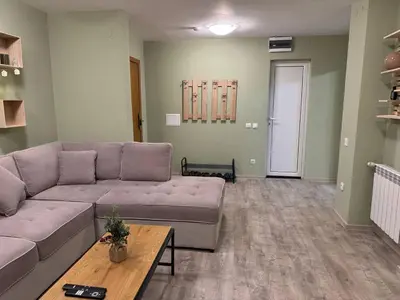 a living room with a couch and a table at Olive Apartment with terrace B100 in Grand Resort Pamporovo in Pamporovo