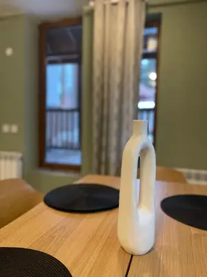 a white vase sitting on top of a wooden table at Olive Apartment with terrace B100 in Grand Resort Pamporovo in Pamporovo