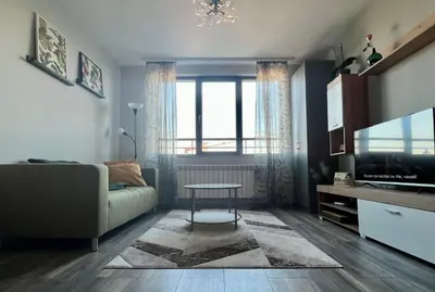 a living room with a couch and a tv at Habitat 29 Apartment in Sofia