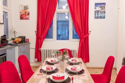 a dining room with a table and red chairs at Vintage bohemian Paradise with Xbox Series X for BIG groups in Sofia