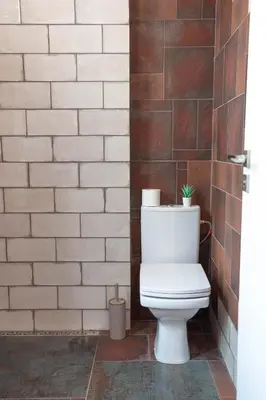 a toilet in a bathroom with a brick wall at Vintage bohemian Paradise with Xbox Series X for BIG groups in Sofia