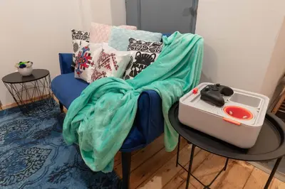 a blue chair with a blanket on top of it at Vintage bohemian Paradise with Xbox Series X for BIG groups in Sofia