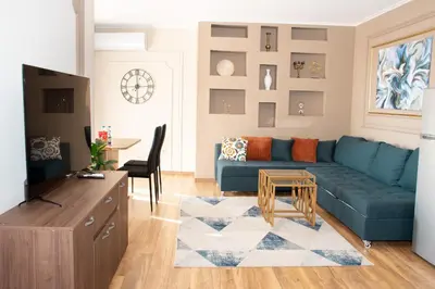 a living room with a blue couch and a table at Gondola Apartments Lux in Bansko