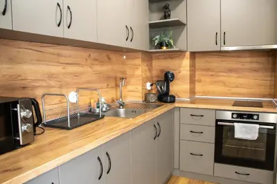 a kitchen with white cabinets and a sink at Gondola Apartments Lux in Bansko