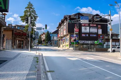 an empty street in a town with buildings and a traffic light at Gondola Apartments Lux in Bansko