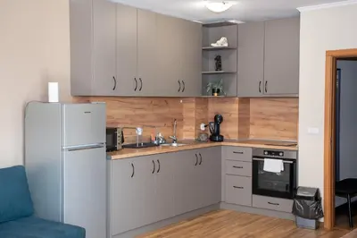 a kitchen with white cabinets and a refrigerator at Gondola Apartments Lux in Bansko