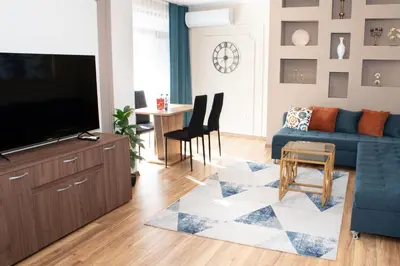 a living room with a blue couch and a table at Gondola Apartments Lux in Bansko