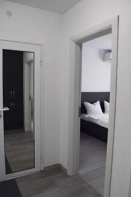 an open door to a bedroom with a bed and a mirror at Orpheus and Eurydice in Smolyan