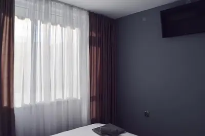 a bedroom with a bed and a large window at Orpheus and Eurydice in Smolyan