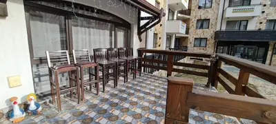 a balcony with chairs and tables on a building at Apartment at Dream Bansko in Bansko