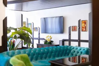 a living room with a blue couch and a mirror at Armaco Residence in Koprivshtitsa