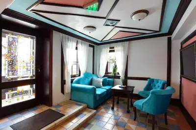 a living room with two blue chairs and a table at Armaco Residence in Koprivshtitsa
