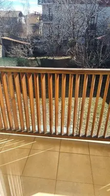 a wooden bench sitting on top of a balcony at Банско Апартментс in Bansko