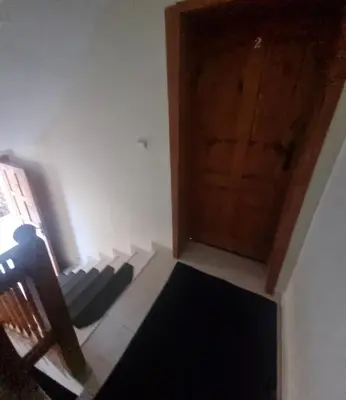 a room with a door and a chair and a rug at Банско Апартментс in Bansko