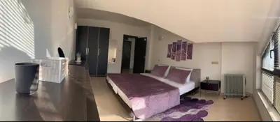a bedroom with a bed with a purple blanket at Central Art Apartment in Bansko with Mountain View in Bansko