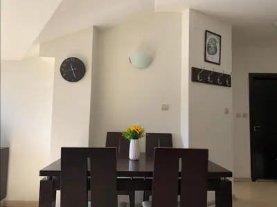 a dining room with a table and chairs and a clock at Central Art Apartment in Bansko with Mountain View in Bansko