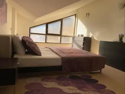 a bedroom with a bed and a large window at Central Art Apartment in Bansko with Mountain View in Bansko