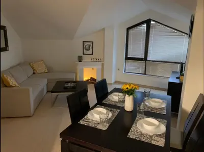 a living room with a table and a couch at Central Art Apartment in Bansko with Mountain View in Bansko