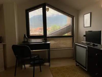 a room with a desk and a window with a computer at Central Art Apartment in Bansko with Mountain View in Bansko